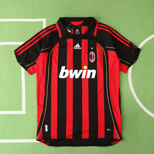 Milan red and black striped sports jersey with Adidas and bwin logos on a green background
